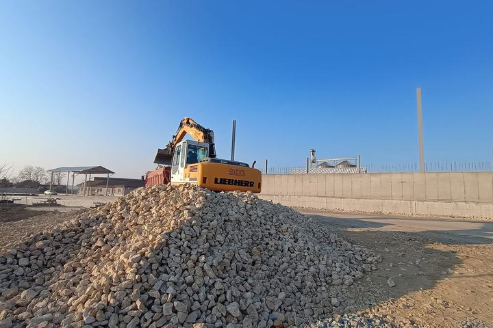 Excavator încărcând agregate reciclate într-o autobasculantă