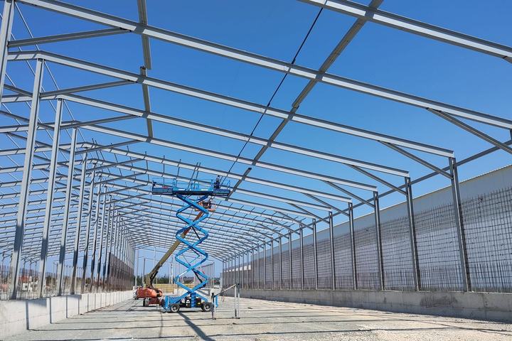 Interiorul unei hale în montaj, structura acoperișului metalic văzută de jos