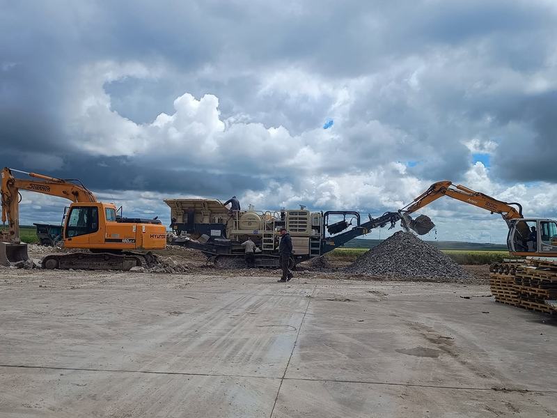 Concasor mobil și două excavatoare la reciclarea betonului