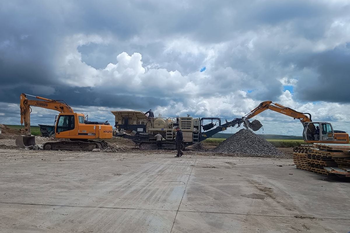 Concasor mobil și două excavatoare la reciclarea betonului pe șantier