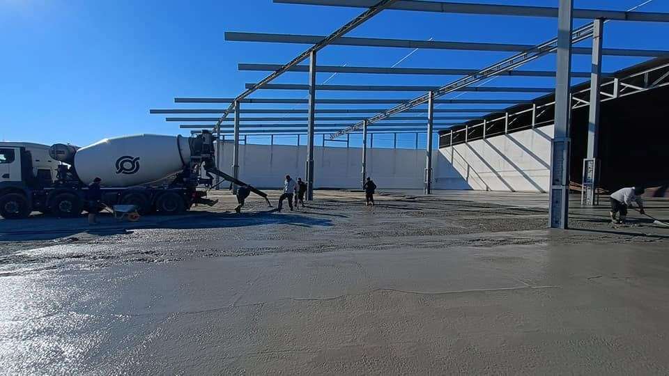 Autobetonieră descărcând beton pe platforma unei hale
