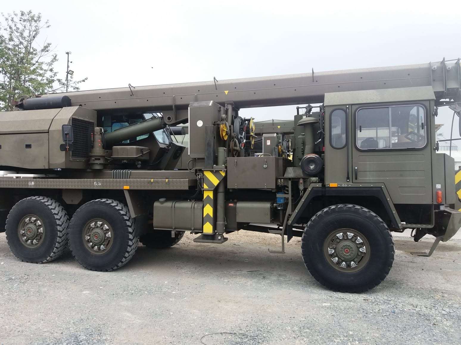 Automacara pe șasiu 6×6 cu brațul ridicat, pe șantier