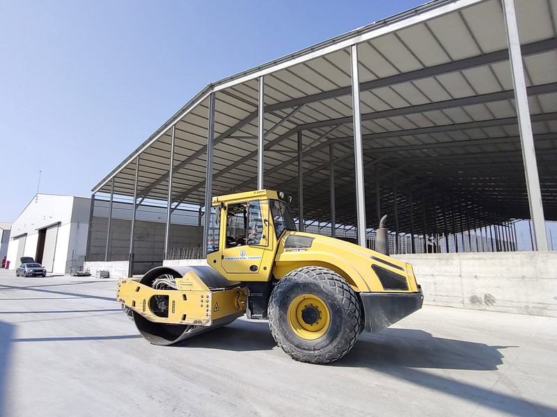 Cilindru compactor galben, pe platformă betonată